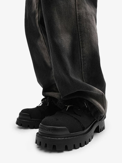 Close-up of star-shaped eyelets on black chunky platform trainers