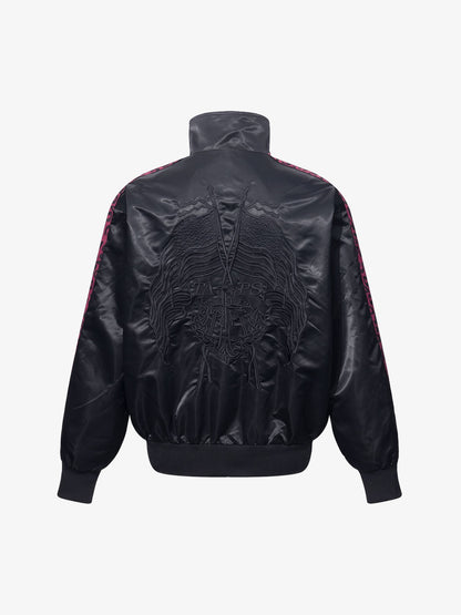 Close-up of the embroidered butterfly detail on the satin jacket
