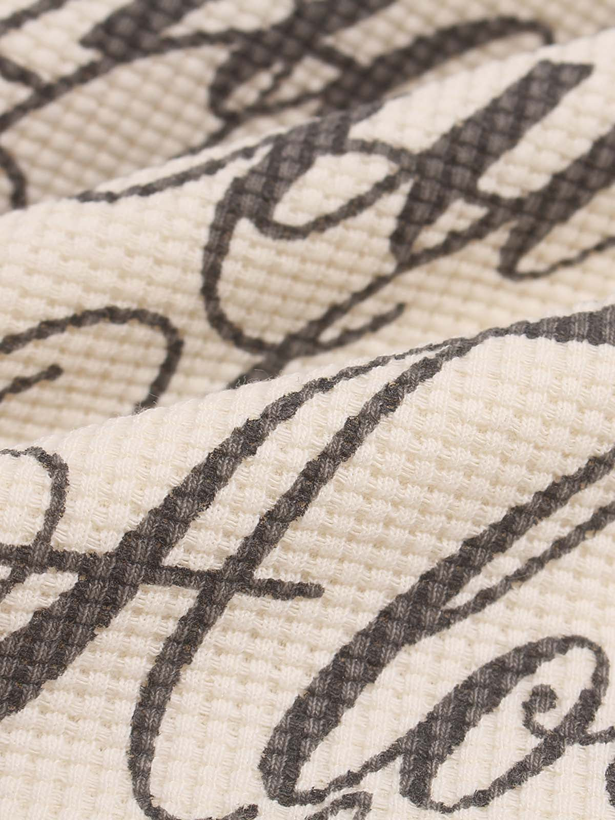 Close-up of the printed lettering on the casual long-sleeve top
