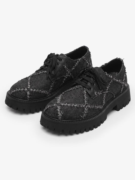 Pair of chunky black platform derby shoes with lace-up fronts
