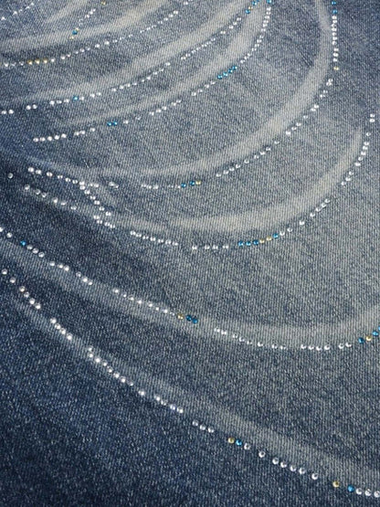 Side view of embellished jeans highlighting the curved-leg cut