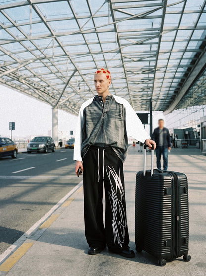 Wide-leg sweatpants shown from the front with a multi-line design