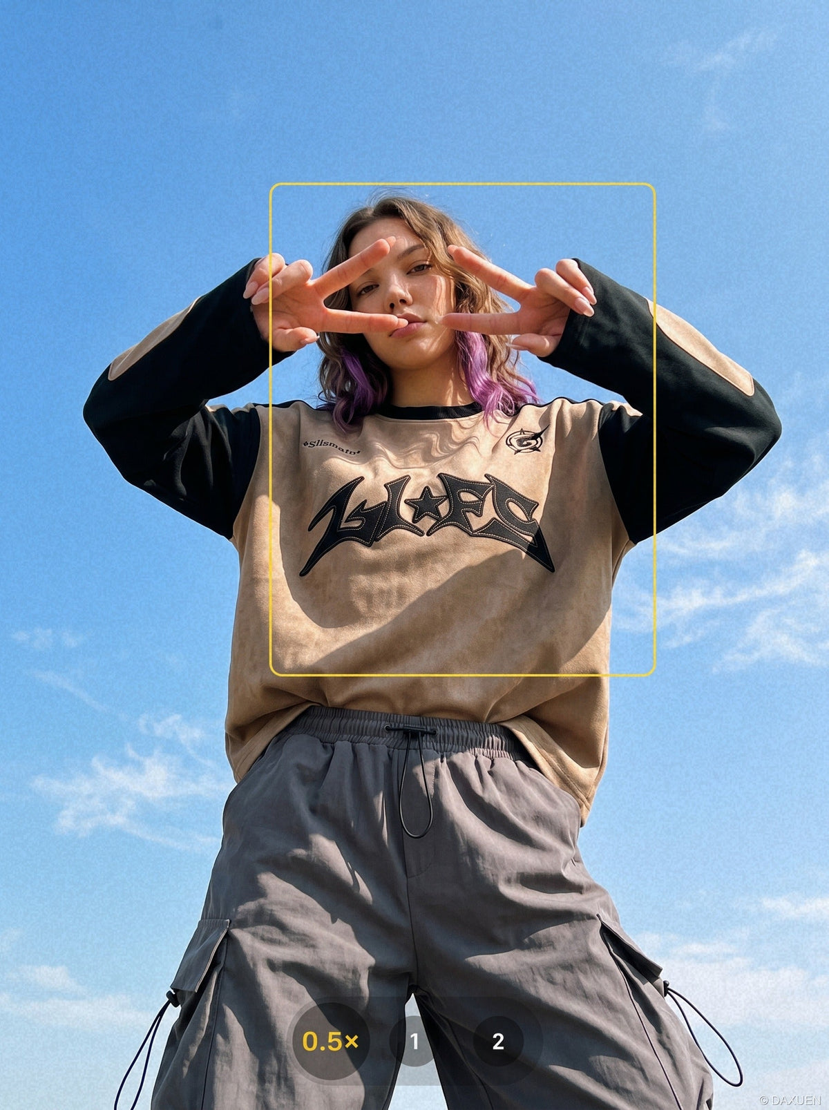 Close-up of the appliqué graphic detail on a long-sleeve top