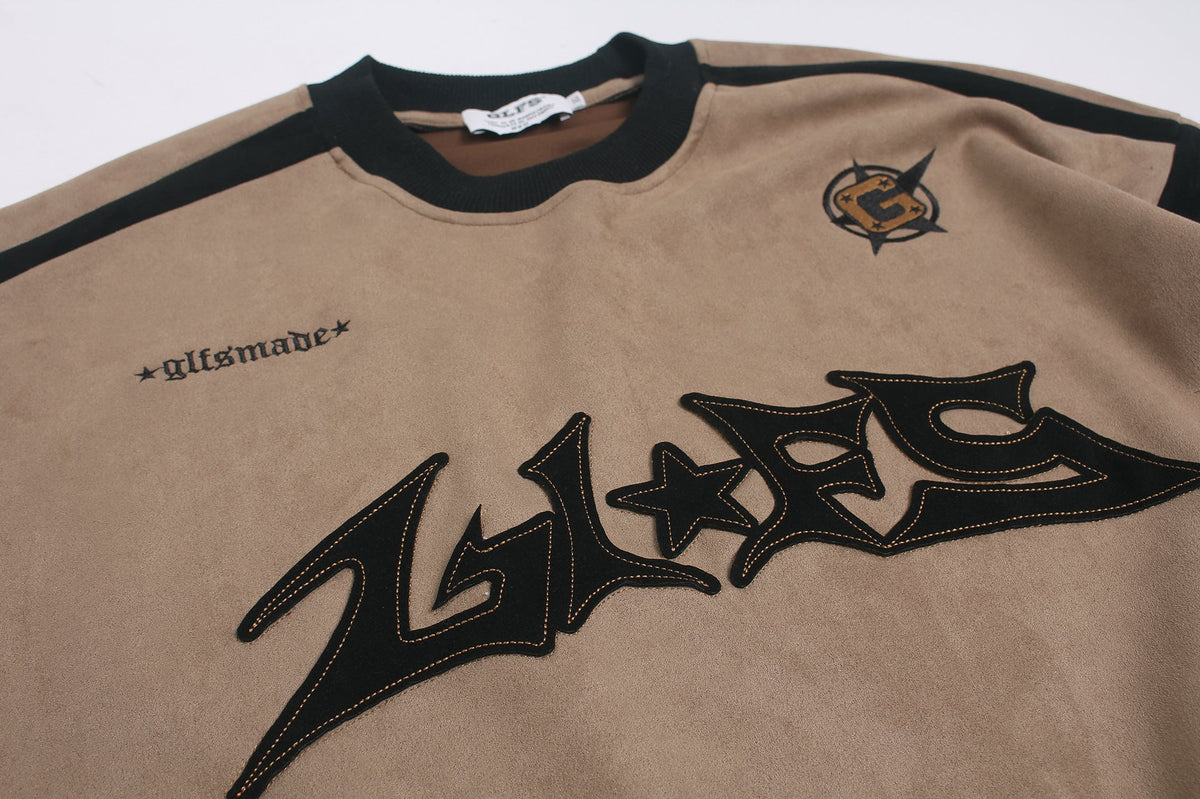 Full view of the graphic long-sleeve top with appliqué detail