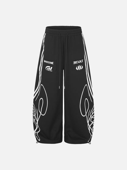Front view of black and grey sweatpants with a bold winged graphic