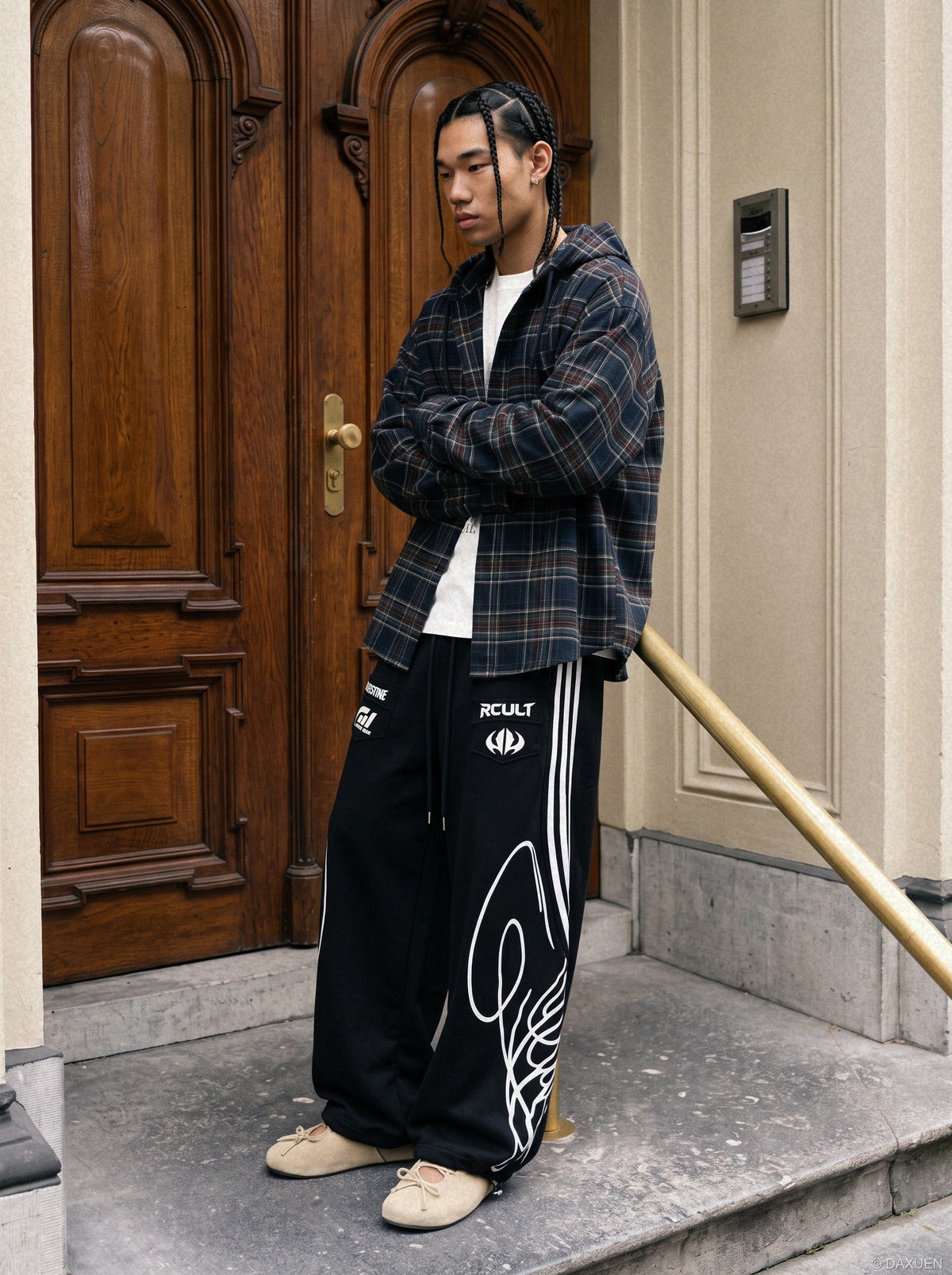Close-up of the winged graphic on black and grey sweatpants