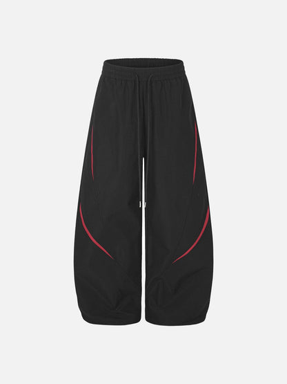 Black tracksuit bottoms with red detailing and star graphic style