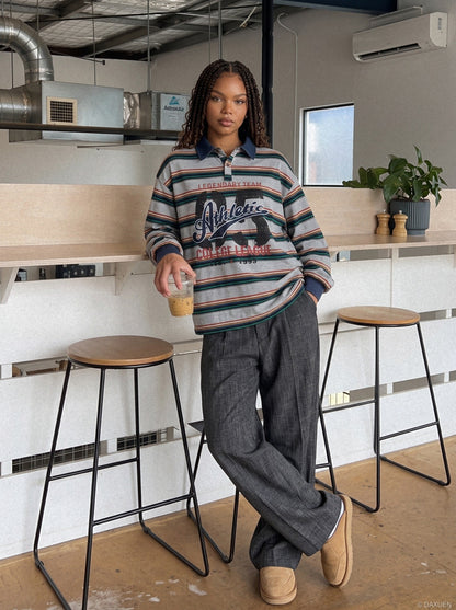 Side view of the oversized striped graphic polo shirt on a model