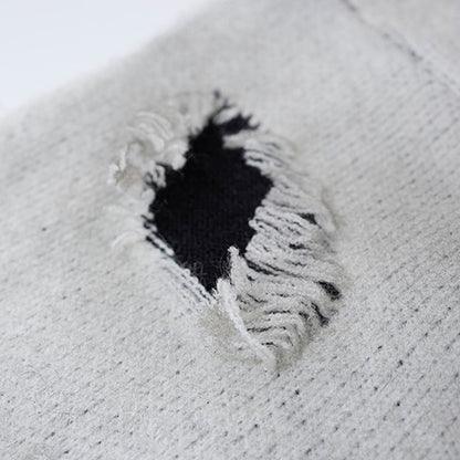 Close-up of the sweater neckline and cross graphic