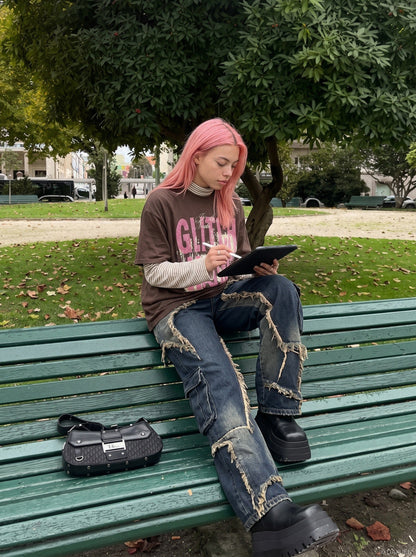 Model wearing oversized layered graphic T-shirt in distressed pink