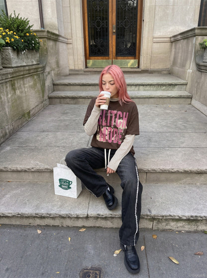 Side view of distressed pink oversized graphic T-shirt with layered sleeves