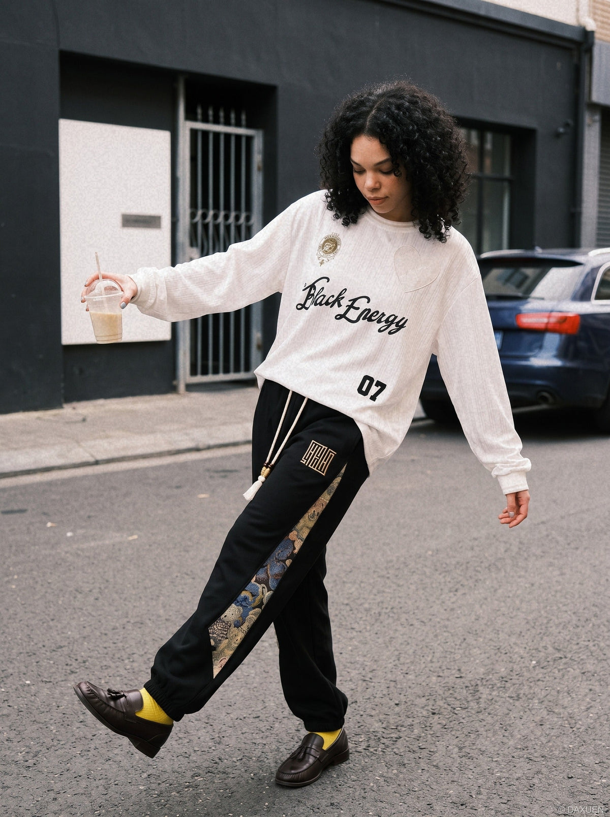 Close-up of embroidered crest detail on oversized jersey T-shirt