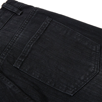 Detail of waistband and pocket on faded black denim shorts