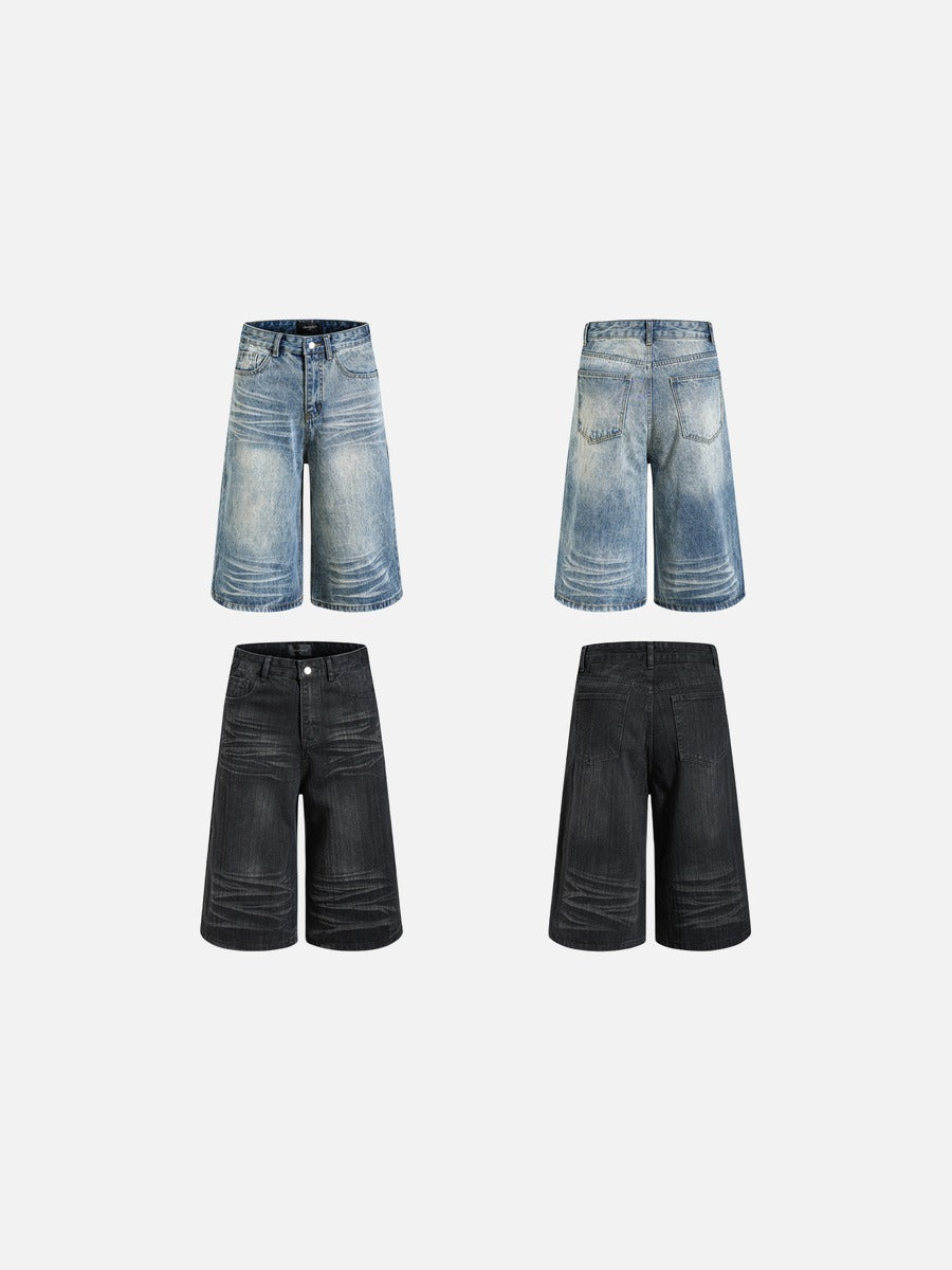 Angled view of faded black wide-leg denim shorts