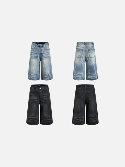 Angled view of faded black wide-leg denim shorts