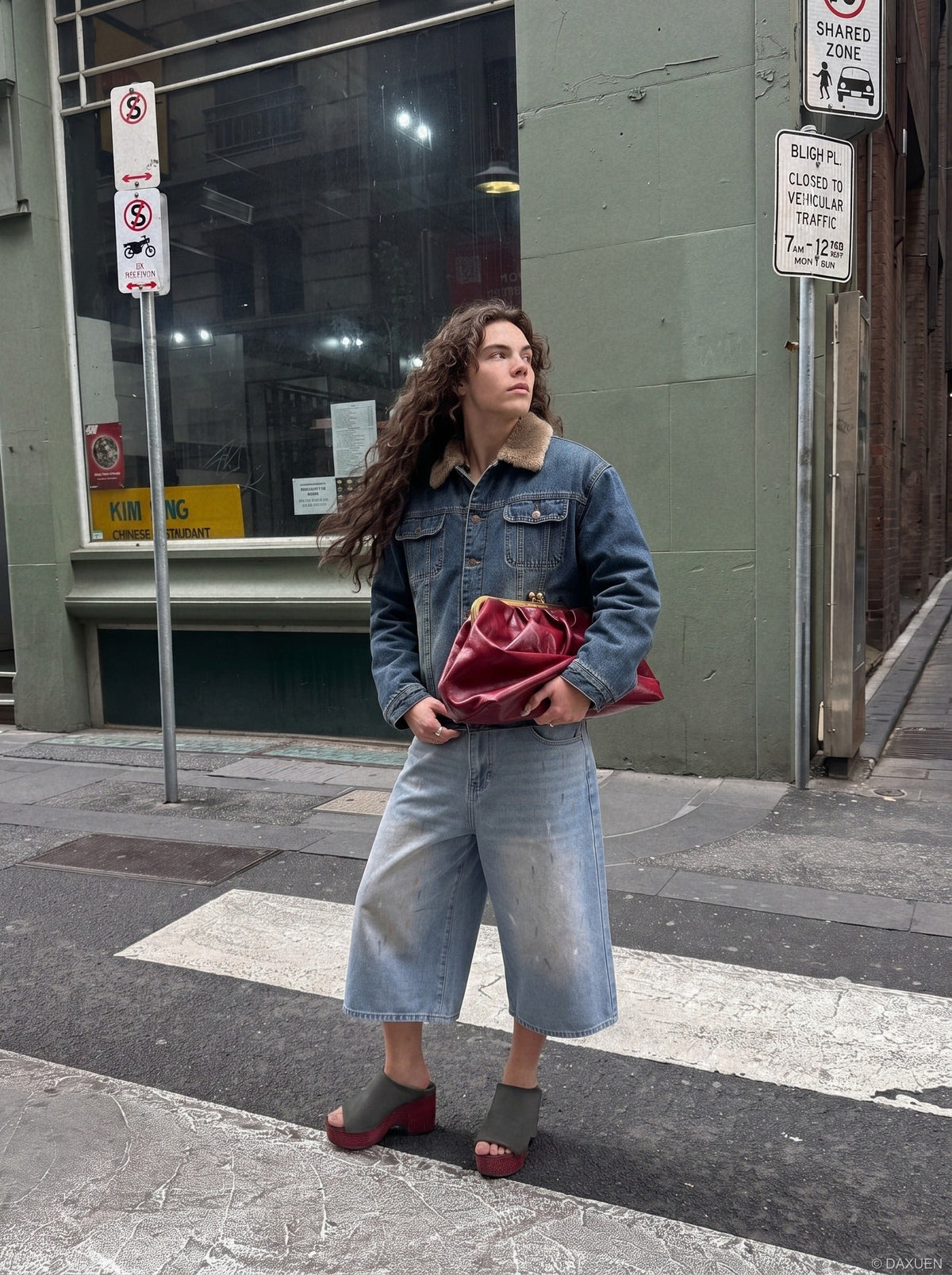 Rear view of faded light blue paint splatter denim culotte shorts
