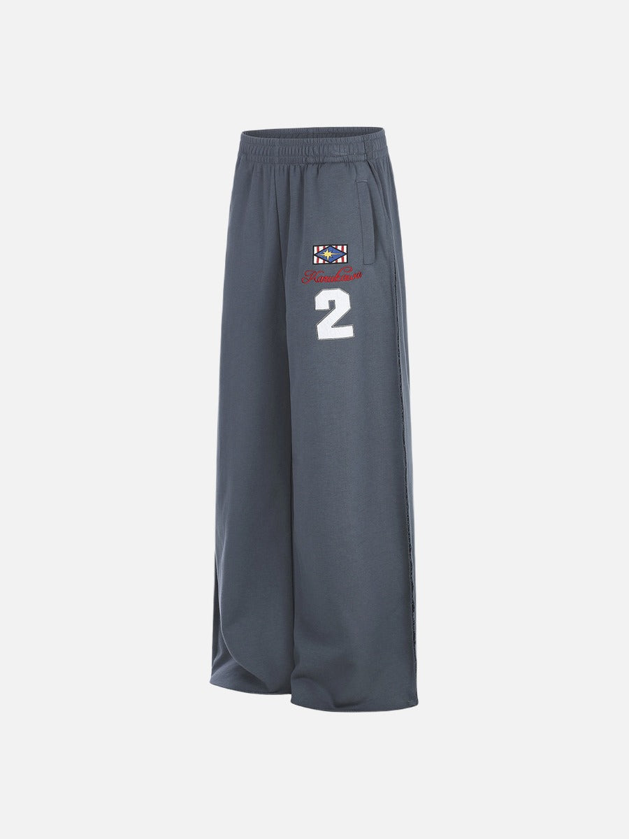 Fabric close-up of graphic sweatpants with embroidered star motif