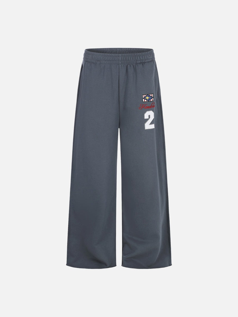 Side view of wide-leg graphic sweatpants showing relaxed fit