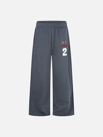 Side view of wide-leg graphic sweatpants showing relaxed fit