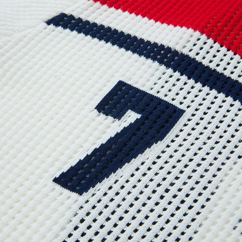 Close-up of button placket on navy open-knit polo shirt