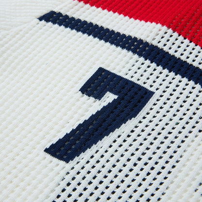 Close-up of button placket on navy open-knit polo shirt