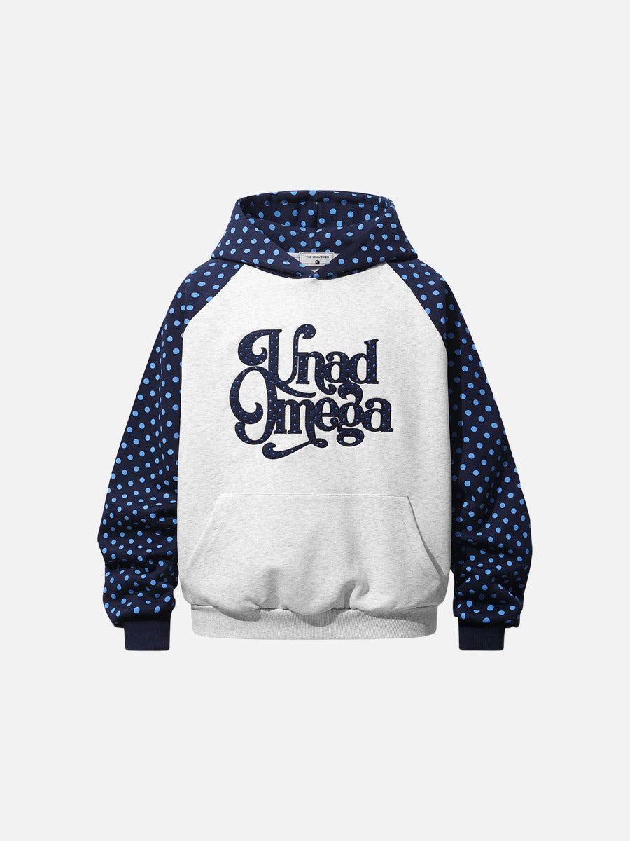 Front view of a polka dot raglan hoodie with graphic script