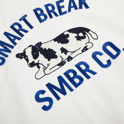 White jacket showing its embroidered cow motif in detail