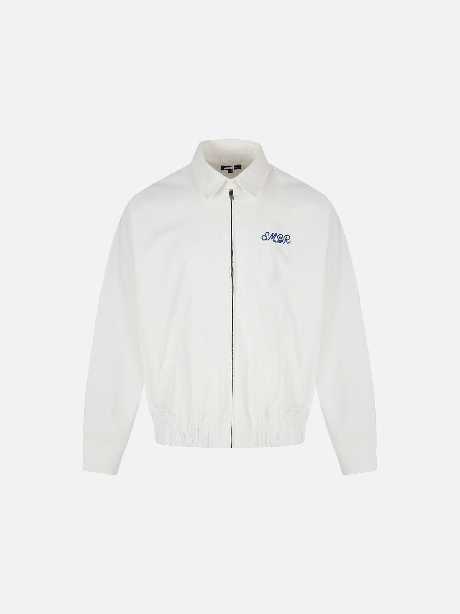 Front view of a white embroidered jacket with a cow graphic