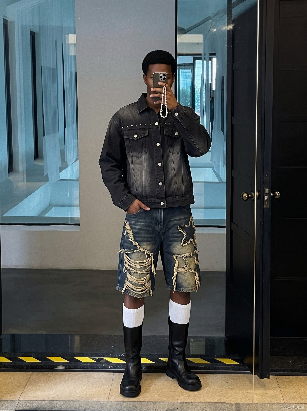 Front view of a studded black denim jacket