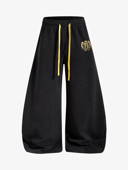 Wide-leg sweatpants with crest graphic shown from the front
