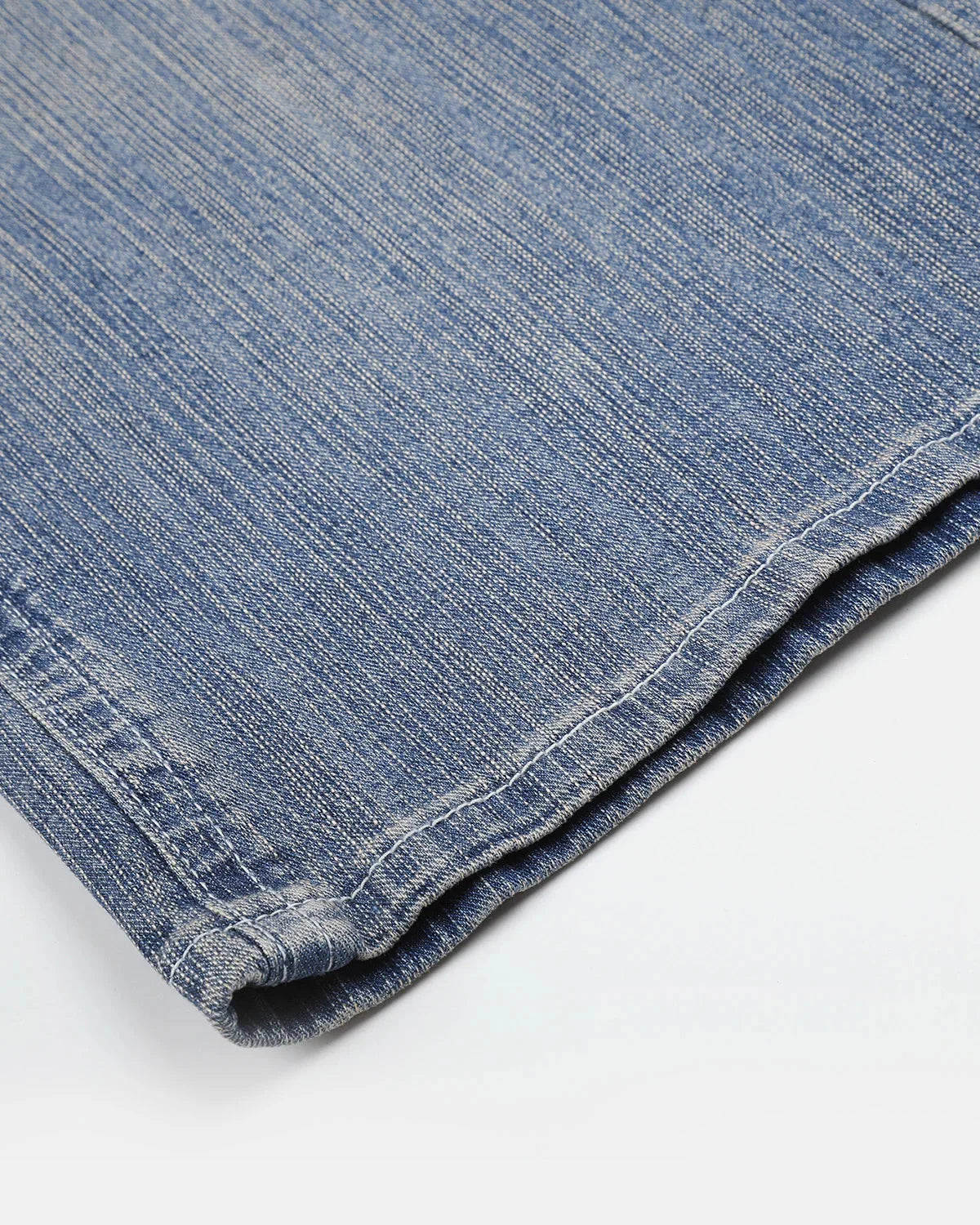 Bootcut leg and hem of embroidered jeans shown close up
