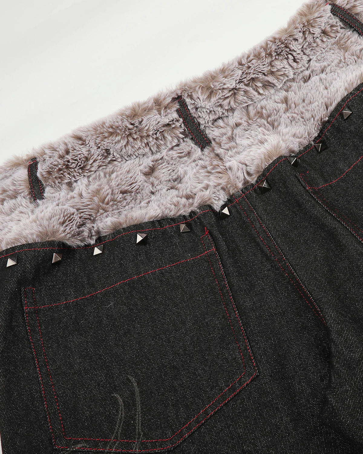 Detail of decorative studs arranged along the jeans waistband